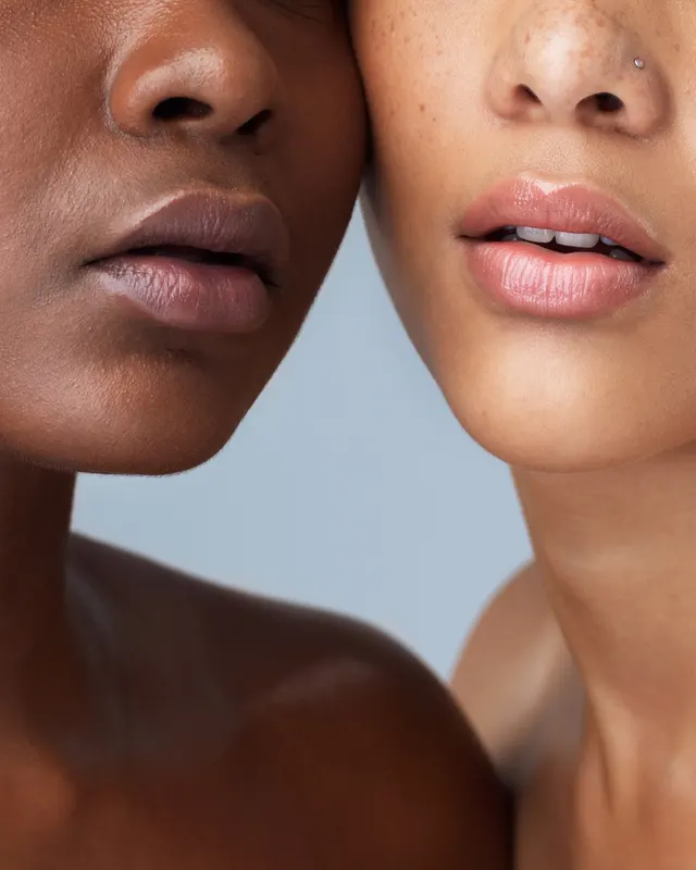 Close portrait of two women with glowing, healthy skin